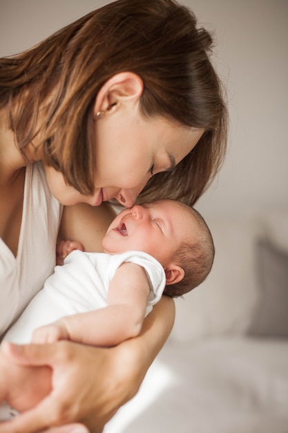 Bébé nouveau-né mignon dormant dans les bras de la mère. Maternité.