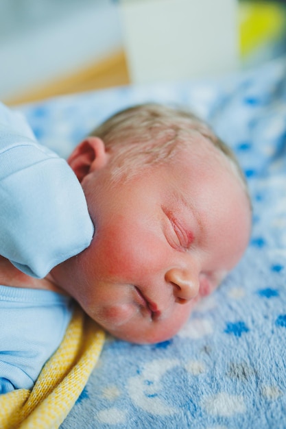 Bébé nouveau-né en romper bleu Photo d'un nouveau-né allongé dans un berceau Les premières photos du bébé