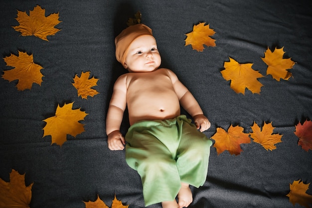 Le bébé nouveau-né se trouve en automne avec des feuilles d'érable