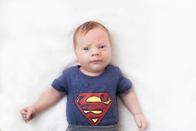 bébé nouveau-né sérieux dans un costume de super-héros sur fond blanc