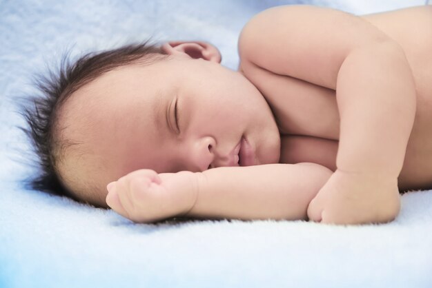 Bébé paisible allongé sur un lit alors qu&#39;il dort dans une pièce lumineuse