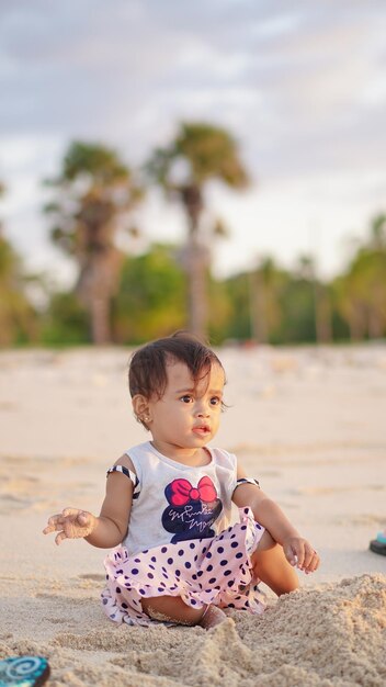 bébé sur la plage jouant dans le sable