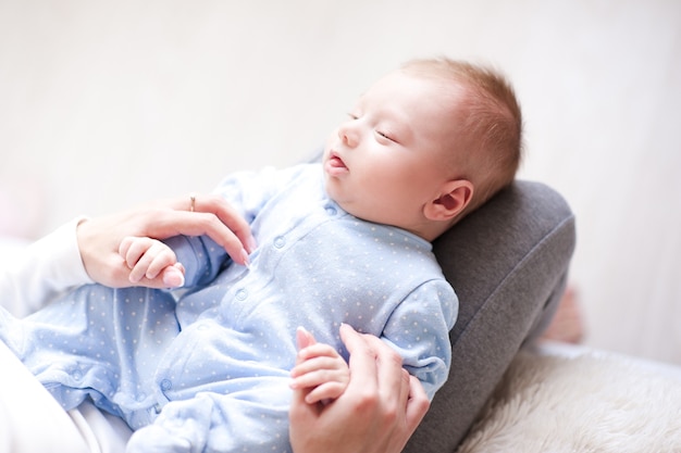 Bébé qui dort avec la mère se tenant la main en gros plan