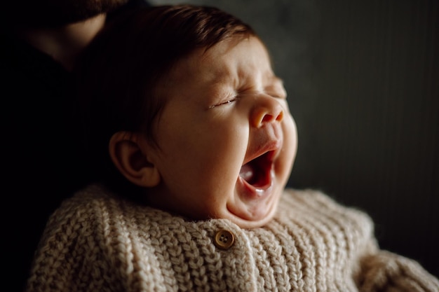 Un bébé qui pleure dans les bras d'un homme