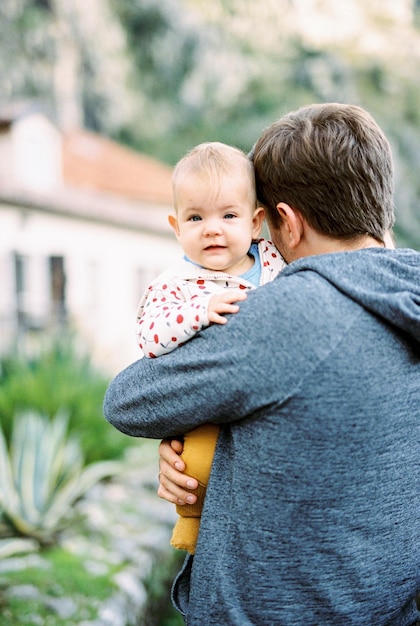 Bébé regarde par-dessus l'épaule du père