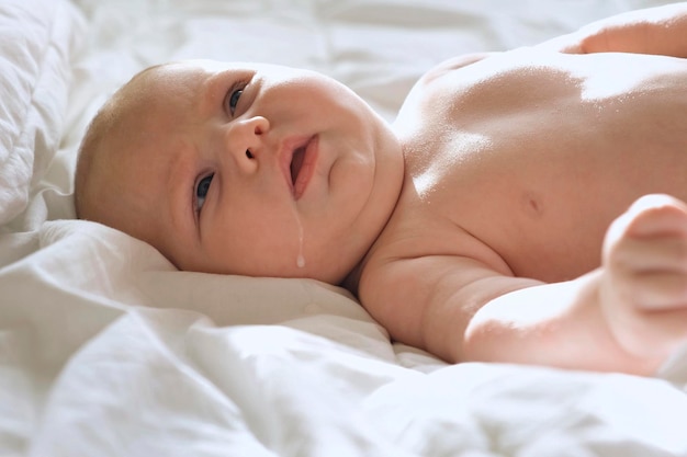 Photo bébé régurgite du lait maternel petit bébé avec du lait sur son visage mignon authentique gros plan d'un adorable nouveau-né concept d'enfance nouvelle vie allaitement maternel parentalité