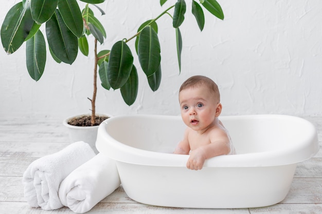 Bébé se baigne dans un bain moussant dans une pièce lumineuse