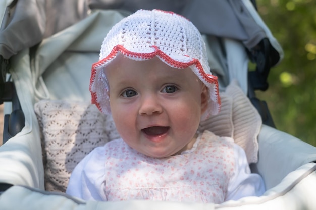 Bébé de sept mois en chapeau blanc souriant
