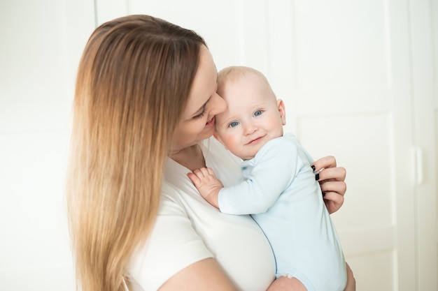 Bébé de six mois dans les bras de maman