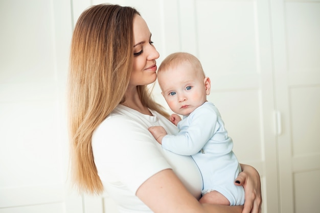 Bébé de six mois dans les bras de maman