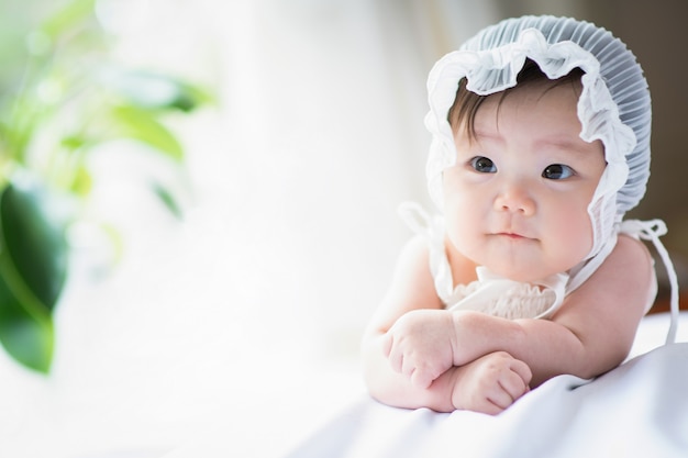 Un bébé souriant et heureux appuyé contre le lit