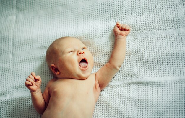 Bébé souriant nouveau-né dans une couche blanche.