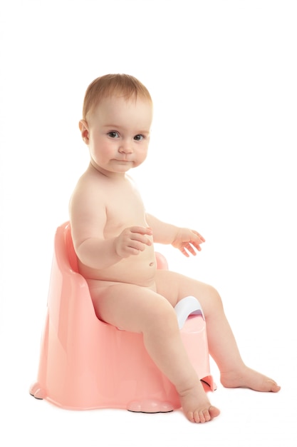 Bébé souriant sur pot de chambre isolé sur fond blanc