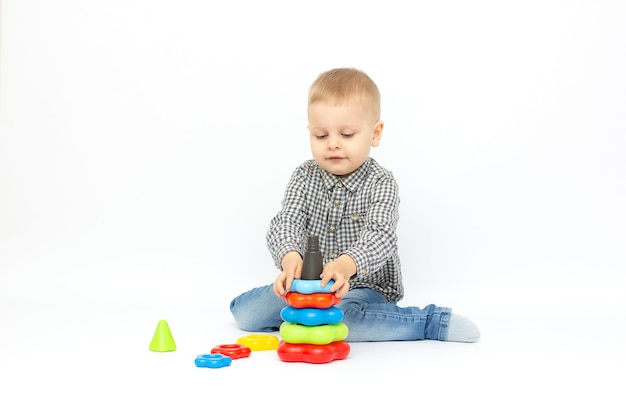 Bébé sur une surface blanche joue avec une pyramide