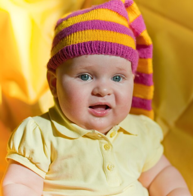 Bébé surpris dans le chapeau jaune et rose