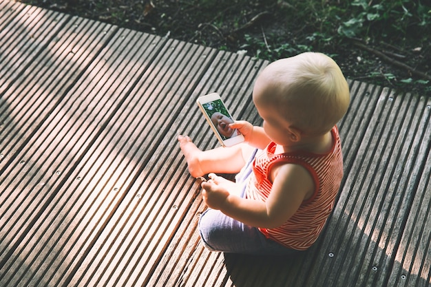 Bébé tenant un téléphone portable et prenant un selfie drôle avec un appareil photo pour téléphone portable