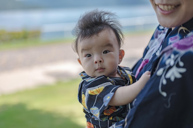 Un bébé tient la main d'une femme.