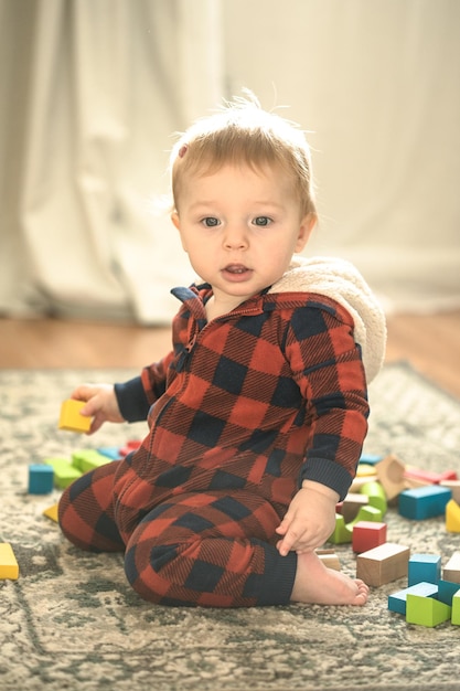 Photo bébé tout-petit jouant à des cubes de couleurs à la maison ou à la pépinière