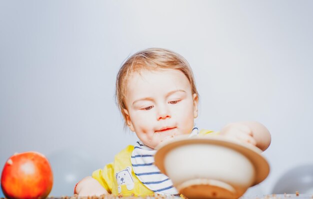 Bébés drôles mignons mangeant de la nourriture pour bébé garçon enfant drôle avec assiette et cuillère