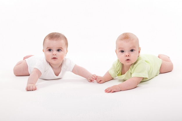 Bébés Fille Et Garçon Couché Sur Un Fond Blanc Et Tenant La Main