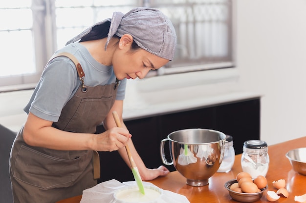 Bécher femme préparant la pâte à gâteau en forme de moule