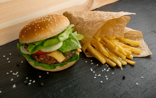 Beefburger avec frites sur fond noir