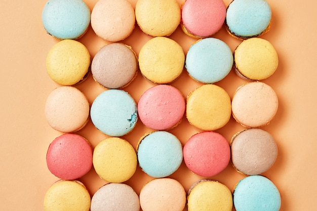 Beige, brun macarons biscuits français sur fond de pêche jaune