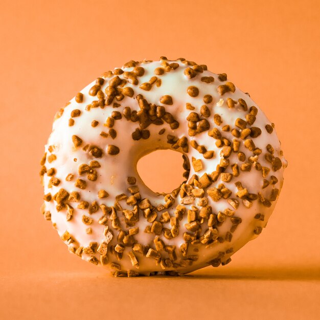 Beignet au chocolat blanc avec garniture aux amandes sur fond rose