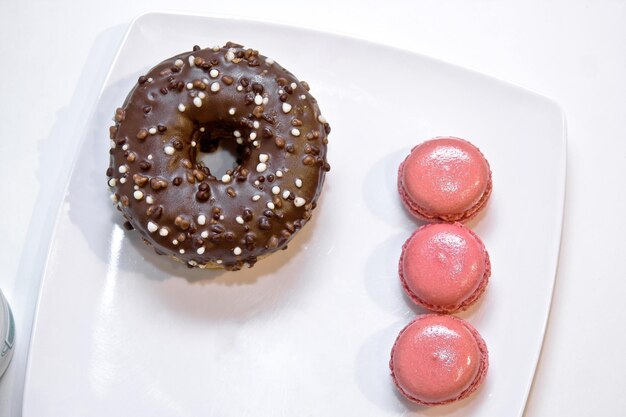 beignet au chocolat avec macarons aux fraises sur une assiette blanche crodots au chocolat dessert food