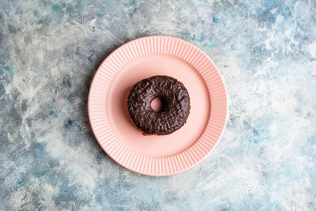 Beignet au chocolat sur plaque rose