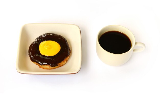 Beignet au chocolat avec une tasse de café isolé sur fond blanc