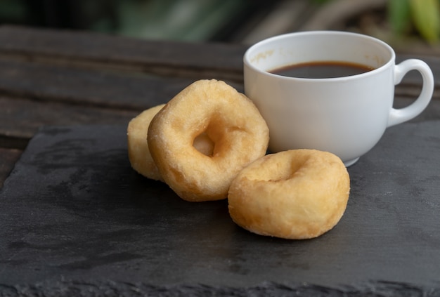 beignet classique et café sur fond de bois.