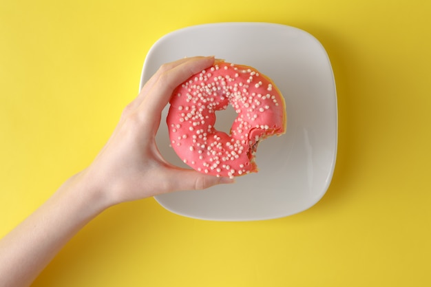 beignet avec glaçage pastel et arrose sur un fond jaune vif