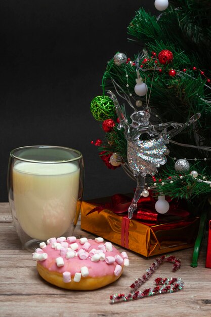Beignet de Noël et lait pour le père Noël un grand verre avec du lait et des décorations de vacances photo d'un christ...