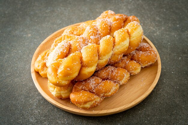 beignet de sucre en forme de spirale sur plaque de bois