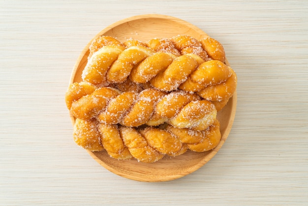 beignet de sucre en forme de spirale sur plaque de bois