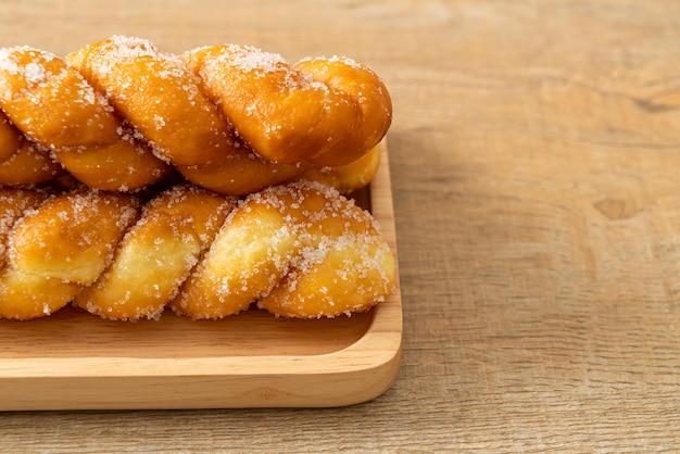 beignet de sucre en forme de spirale sur plaque de bois