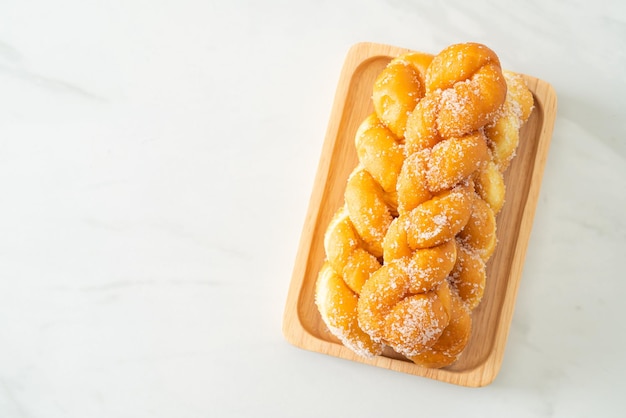 beignet de sucre en forme de spirale sur plaque de bois