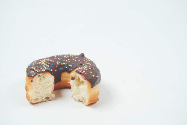 Beignets au chocolat à moitié mangés sur fond blanc