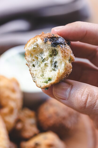 Beignets de brocoli, épinards et oignons avec une sauce au yogourt avec des herbes fraîches.