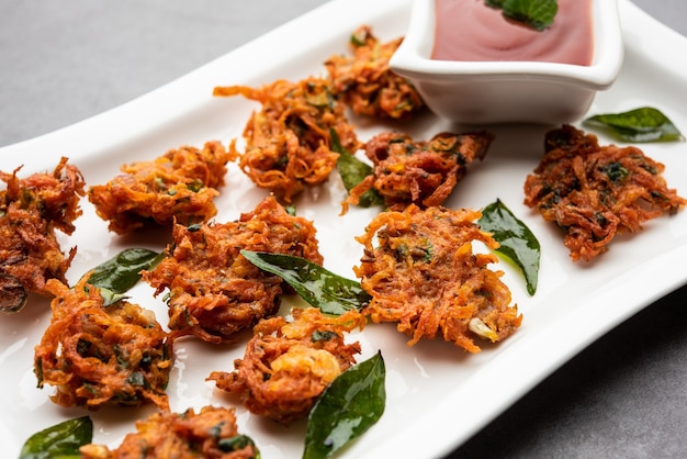 Beignets de carottes ou Gajar ke pakore ou pakode ou bajji ou bhaji, collation indienne servie dans une assiette avec du ketchup à la tomate