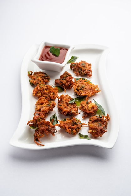 Beignets de carottes ou Gajar ke pakore ou pakode ou bajji ou bhaji, collation indienne servie dans une assiette avec du ketchup à la tomate