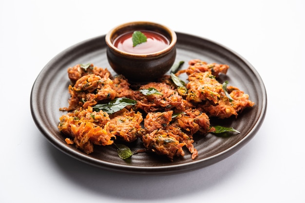 Beignets de carottes ou Gajar ke pakore ou pakode ou bajji ou bhaji, collation indienne servie dans une assiette avec du ketchup à la tomate