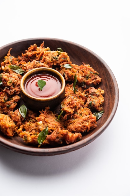 Beignets de carottes ou Gajar ke pakore ou pakode ou bajji ou bhaji, snack indien servi dans une assiette avec du ketchup à la tomate