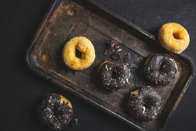 Beignets colorés sur la table noire. Vue de dessus