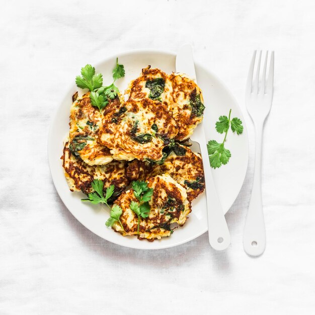 Beignets de courgettes aux épinards délicieux snacks végétariens apéritifs petit déjeuner sur fond clair