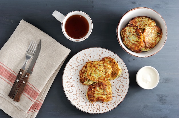 Beignets de courgettes avec du thé sur bois w rustique