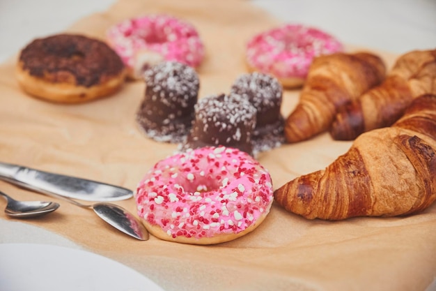 Beignets, croissants et bonbons sur papier kraft