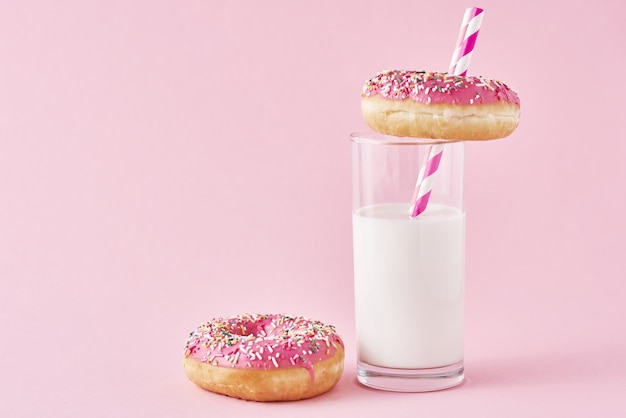 Beignets décorés de glaçage et saupoudrer et verre de lait.