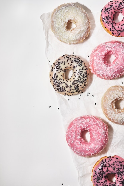 Beignets faits maison avec noix de coco et graines de sésame noir en glaçure multicolore